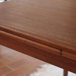 table à manger scandinave en teck massif extensible années 60 avec rallonges intégrées et piètement fuselé