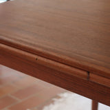 table à manger scandinave en teck massif extensible années 60 avec rallonges intégrées et piètement fuselé