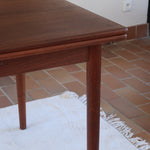 table à manger scandinave en teck massif extensible années 60 avec rallonges intégrées et piètement fuselé