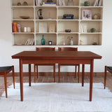 Table à manger scandinave extensible en teck, design danois des années 60, patine chaleureuse et traces du temps légères.
