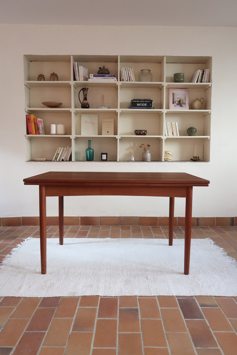 Table à manger scandinave extensible en teck, design danois des années 60, patine chaleureuse et traces du temps légères.
