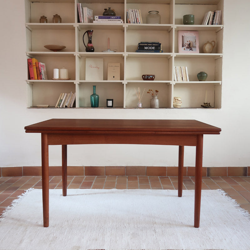 Table à manger scandinave extensible en teck, design danois des années 60, patine chaleureuse et traces du temps légères.
