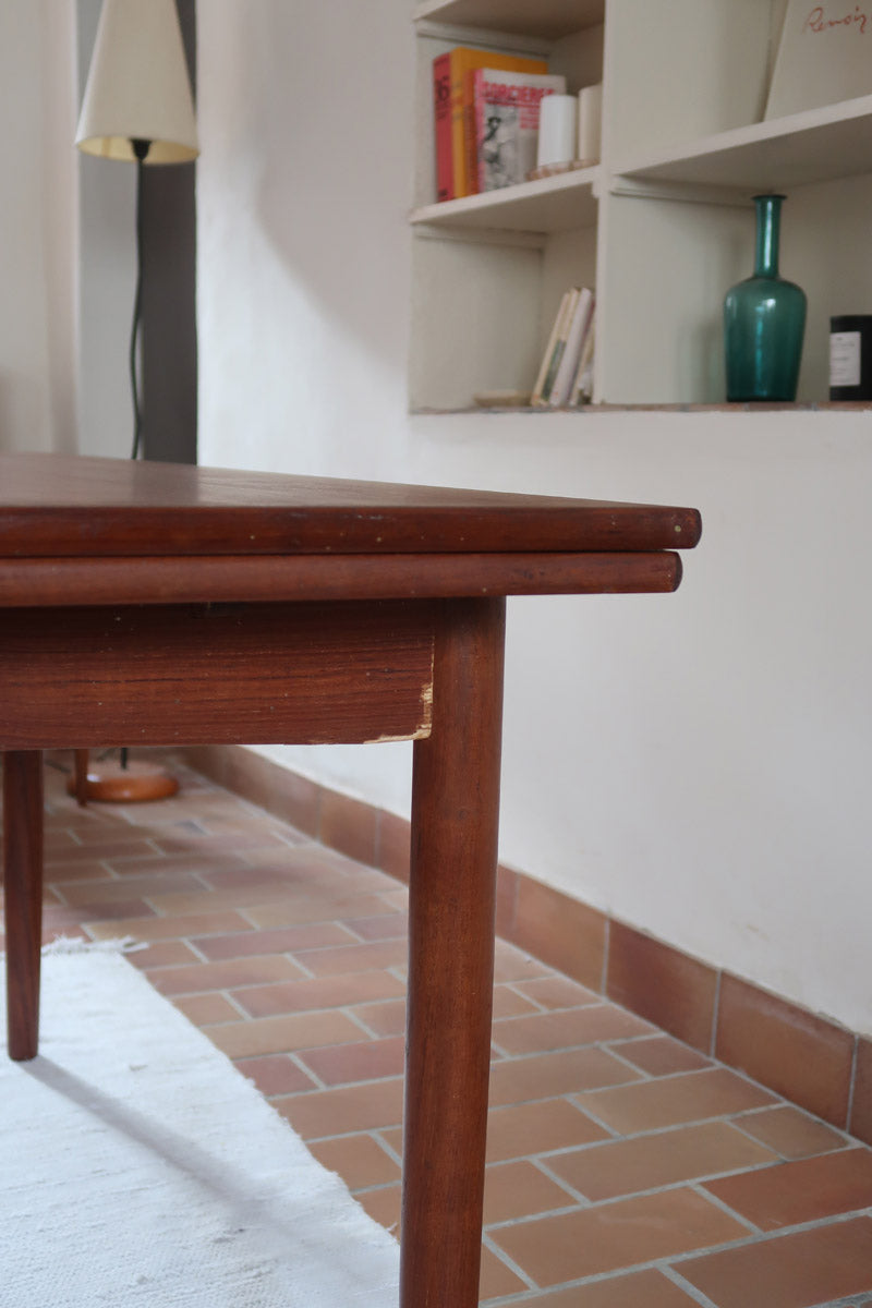 Table à manger scandinave extensible en teck, design danois des années 60, patine chaleureuse et traces du temps légères.
