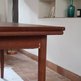 Table à manger scandinave extensible en teck, design danois des années 60, patine chaleureuse et traces du temps légères.
