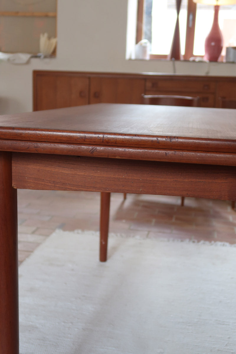 Table à manger scandinave extensible en teck, design danois des années 60, patine chaleureuse et traces du temps légères.
