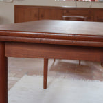 Table à manger scandinave extensible en teck, design danois des années 60, patine chaleureuse et traces du temps légères.
