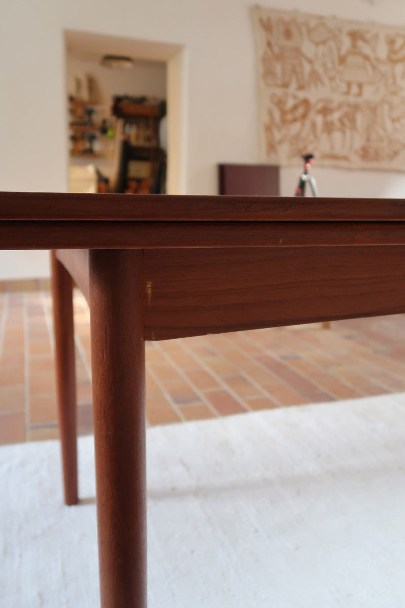 Table à manger scandinave extensible en teck, design danois des années 60, patine chaleureuse et traces du temps légères.
