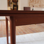 Table à manger scandinave extensible en teck, design danois des années 60, patine chaleureuse et traces du temps légères.
