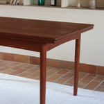 Table à manger scandinave extensible en teck, design danois des années 60, patine chaleureuse et traces du temps légères.
