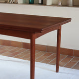 Table à manger scandinave extensible en teck, design danois des années 60, patine chaleureuse et traces du temps légères.
