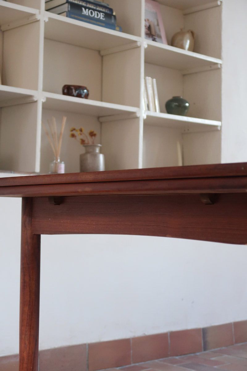 Table à manger scandinave extensible en teck, design danois des années 60, patine chaleureuse et traces du temps légères.
