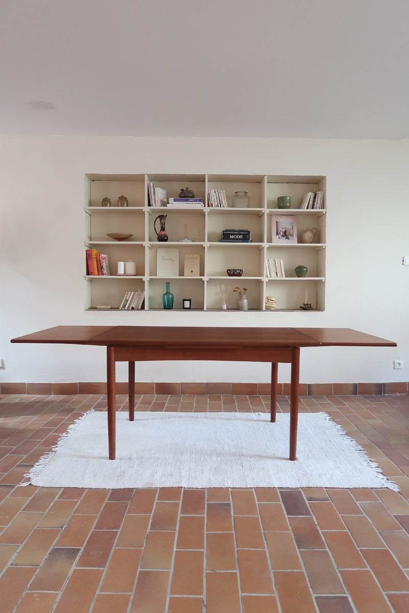 Table à manger scandinave extensible en teck, design danois des années 60, patine chaleureuse et traces du temps légères.
