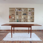 Table à manger scandinave extensible en teck, design danois des années 60, patine chaleureuse et traces du temps légères.
