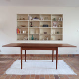 Table à manger scandinave extensible en teck, design danois des années 60, patine chaleureuse et traces du temps légères.
