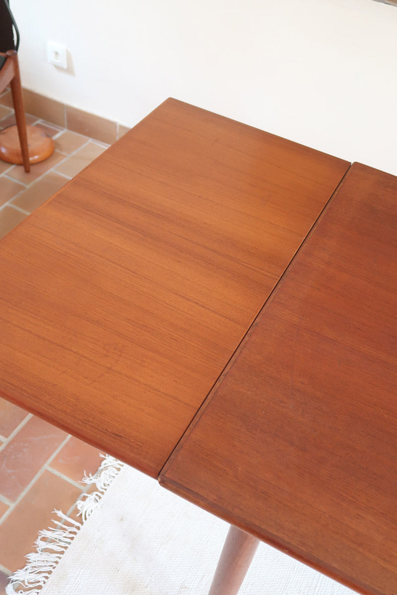 Table à manger scandinave extensible en teck, design danois des années 60, patine chaleureuse et traces du temps légères.

