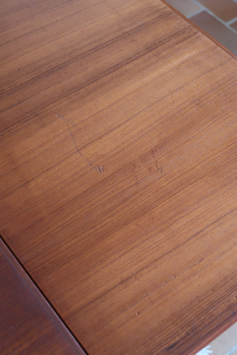 Table à manger scandinave extensible en teck, design danois des années 60, patine chaleureuse et traces du temps légères.
