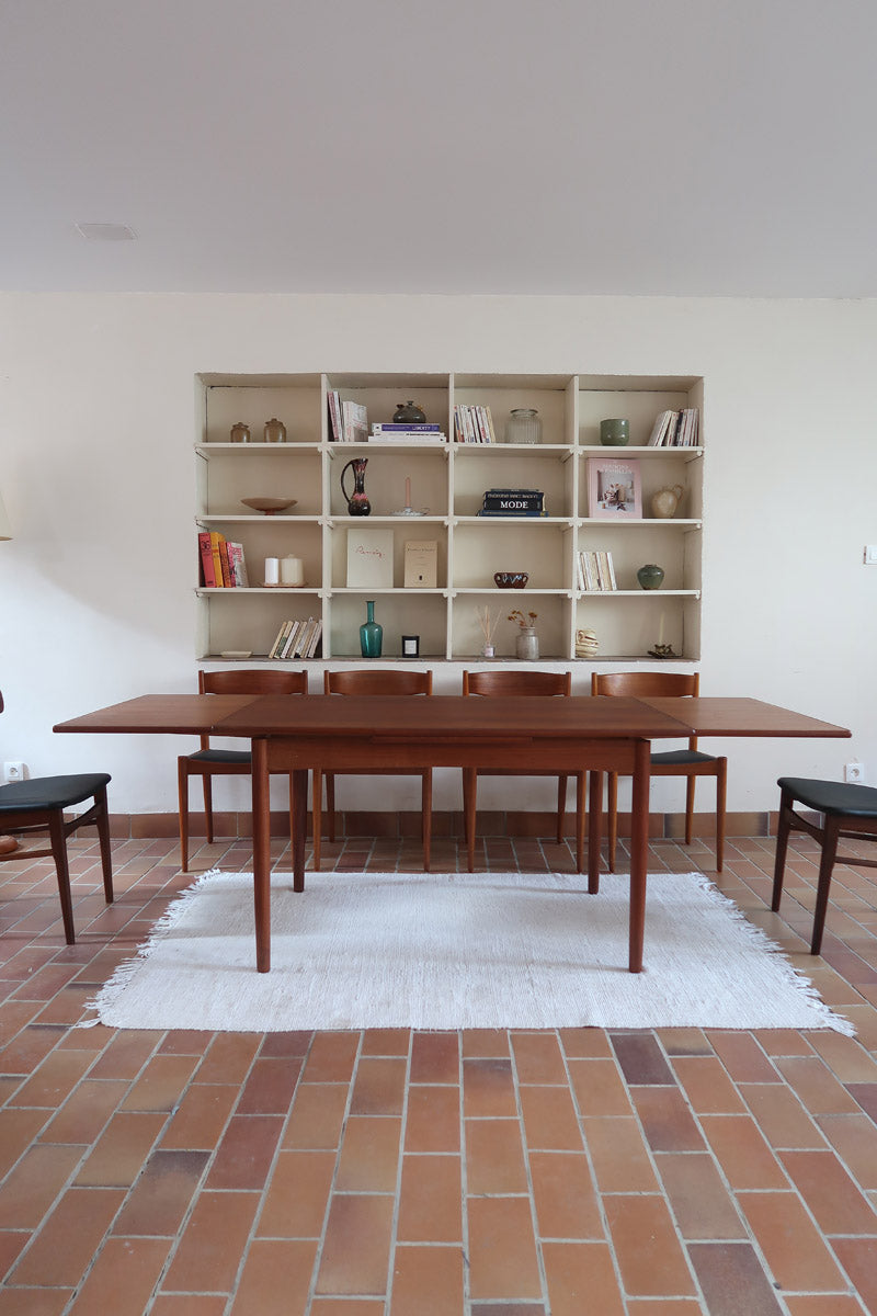 Table à manger scandinave extensible en teck, design danois des années 60, patine chaleureuse et traces du temps légères.

