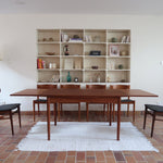 Table à manger scandinave extensible en teck, design danois des années 60, patine chaleureuse et traces du temps légères.
