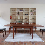 Table à manger scandinave extensible en teck, design danois des années 60, patine chaleureuse et traces du temps légères.
