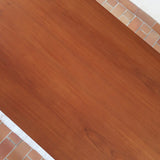 Table à manger scandinave en teck avec deux rallonges intégrées, design années 60, photographiée dans un intérieur lumineux.