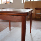 Table à manger scandinave en teck des années 60 avec deux rallonges intégrées et pieds fuselés.