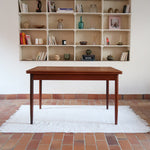 Table à manger scandinave en teck des années 60 avec deux rallonges intégrées et piètement fuselé.