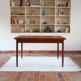 Table à manger scandinave en teck des années 60 avec deux rallonges intégrées et piètement fuselé.