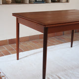 Table à manger scandinave en teck des années 60 avec deux rallonges intégrées et piètement fuselé.