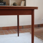 Table à manger scandinave en teck des années 60 avec deux rallonges intégrées et piètement fuselé.