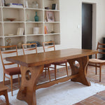 Table à manger vintage en bois massif années 60, plateau épais à chant brut, piétement traîneau sculpté, clé de tenon en croix, travail brutaliste français