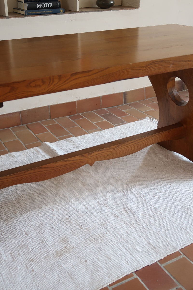 Table à manger vintage en bois massif années 60, plateau épais à chant brut, piétement traîneau sculpté, clé de tenon en croix, travail brutaliste français