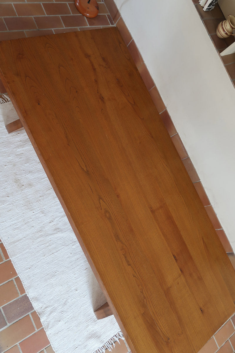 Table à manger vintage en bois massif années 60, plateau épais à chant brut, piétement traîneau sculpté, clé de tenon en croix, travail brutaliste français