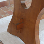 Table à manger vintage en bois massif années 60, plateau épais à chant brut, piétement traîneau sculpté, clé de tenon en croix, travail brutaliste français