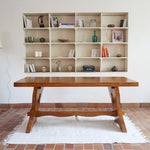 Table à manger vintage en bois massif années 60, plateau épais à chant brut, piétement traîneau sculpté, clé de tenon en croix, travail brutaliste français