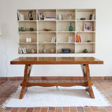 Table à manger vintage en bois massif années 60, plateau épais à chant brut, piétement traîneau sculpté, clé de tenon en croix, travail brutaliste français
