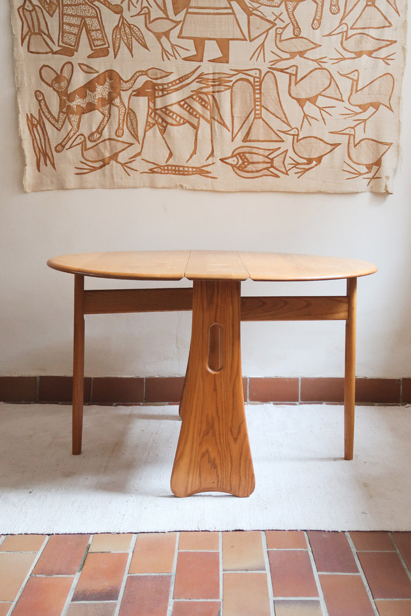 Table Ercol drop leaf en bois massif clair, plateau ovale à abattants, années 70.