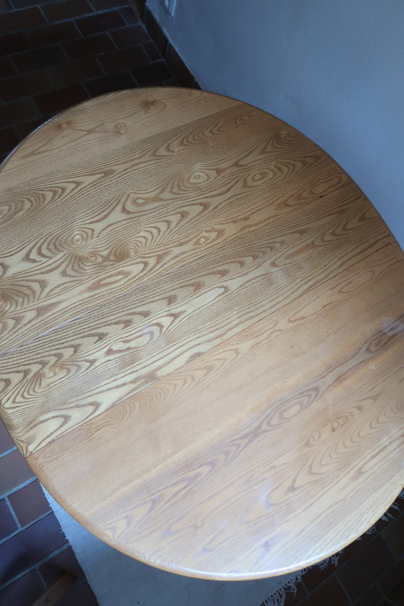 Table Ercol drop leaf en bois massif clair, plateau ovale à abattants, années 70.