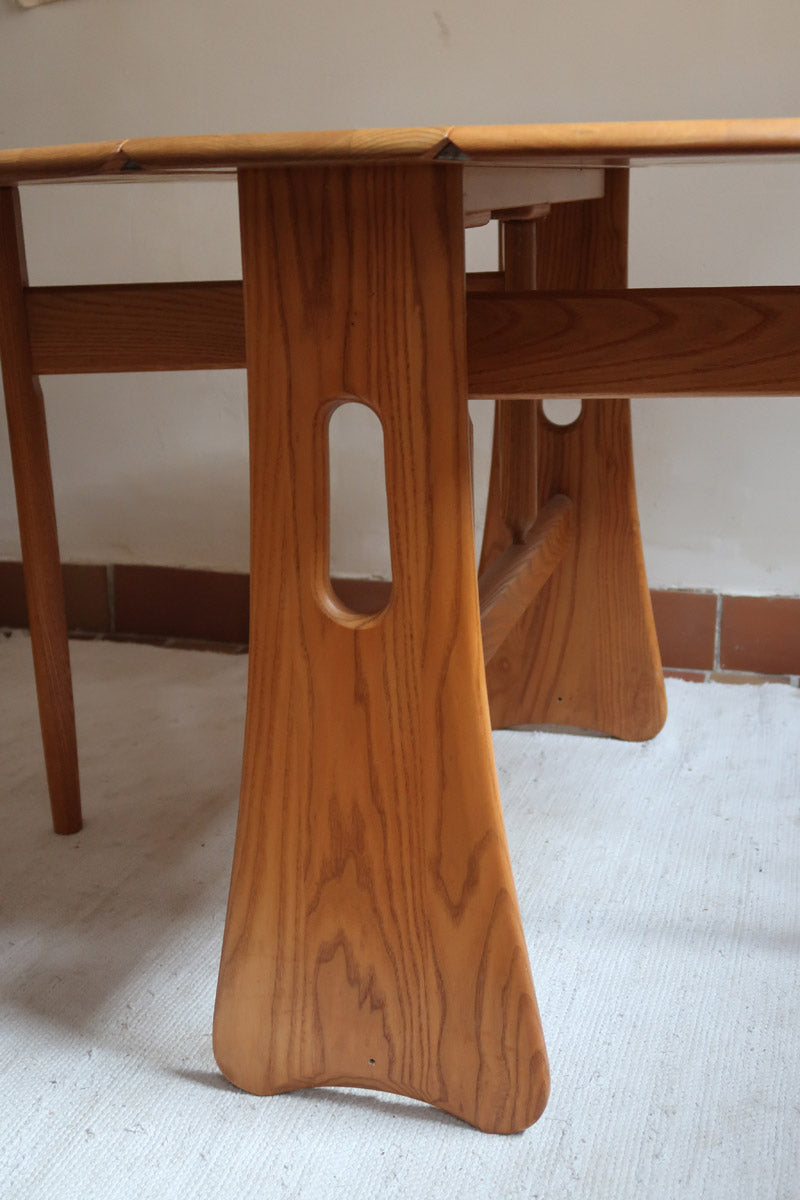 Table Ercol drop leaf en bois massif clair, plateau ovale à abattants, années 70.