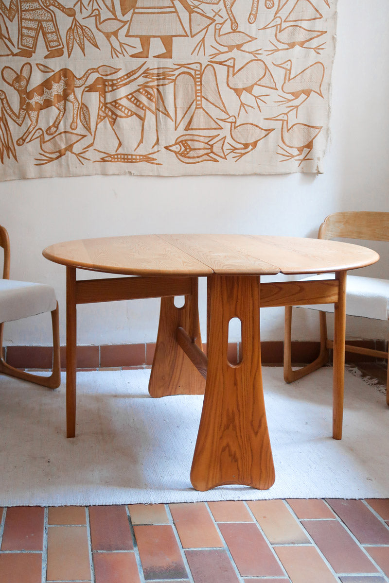 Table Ercol drop leaf en bois massif clair, plateau ovale à abattants, années 70.