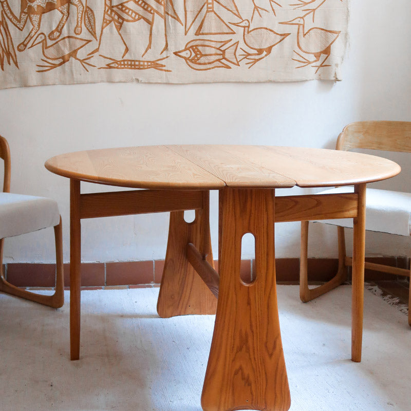 Table Ercol drop leaf en bois massif clair, plateau ovale à abattants, années 70.