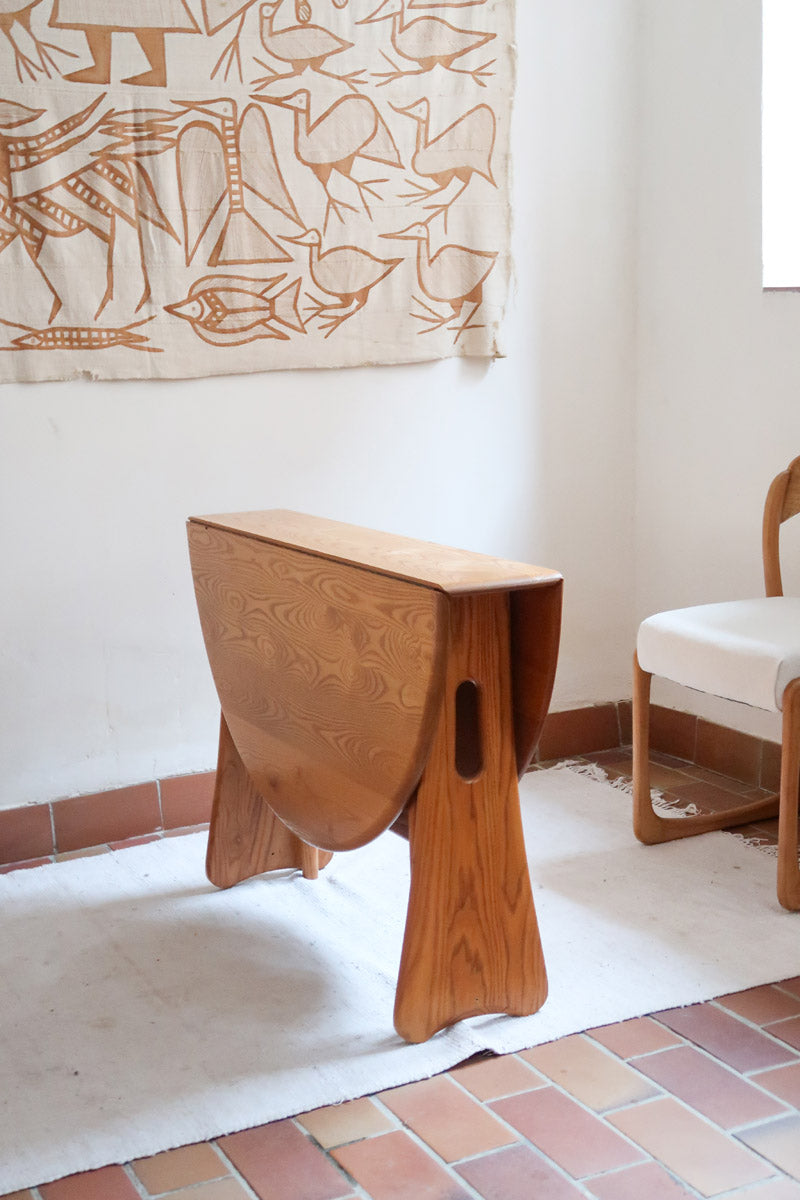 Table Ercol drop leaf en bois massif clair, plateau ovale à abattants, années 70.