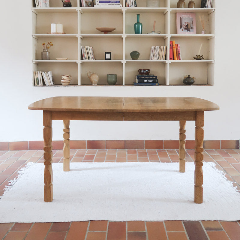 Table extensible Henning Kjærnulf en chêne massif avec pieds sculptés et deux rallonges intégrées, design danois années 60.