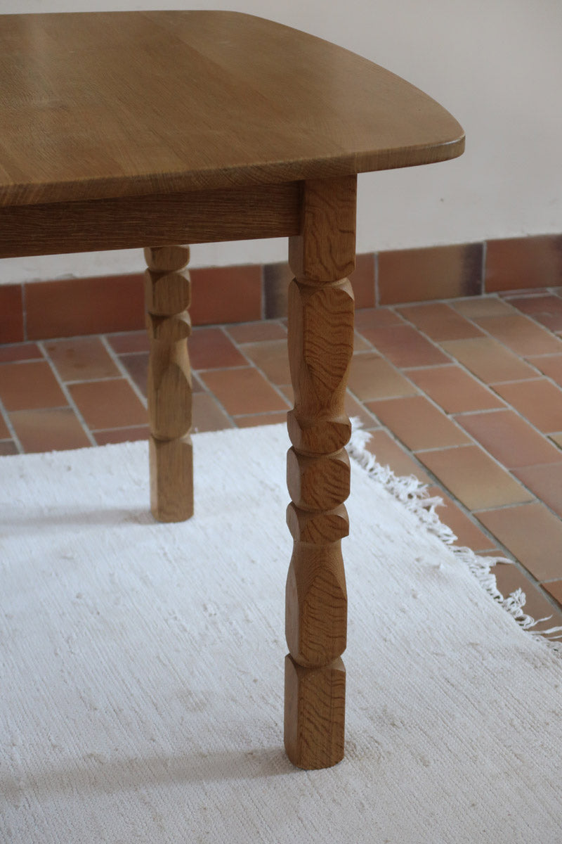 Table extensible Henning Kjærnulf en chêne massif avec pieds sculptés et deux rallonges intégrées, design danois années 60.