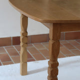 Table extensible Henning Kjærnulf en chêne massif avec pieds sculptés et deux rallonges intégrées, design danois années 60.