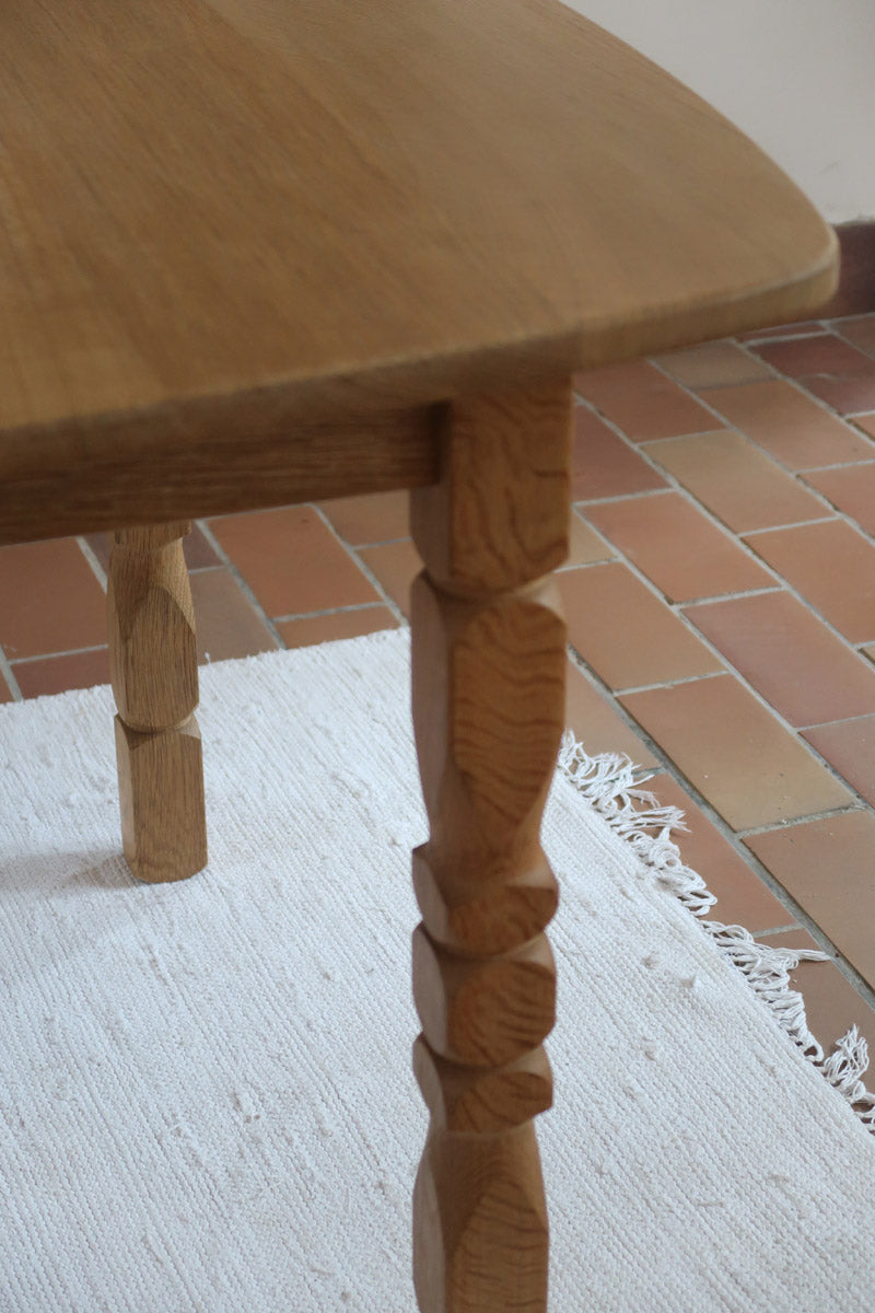 Table extensible Henning Kjærnulf en chêne massif avec pieds sculptés et deux rallonges intégrées, design danois années 60.