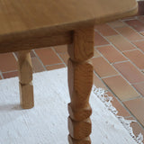 Table extensible Henning Kjærnulf en chêne massif avec pieds sculptés et deux rallonges intégrées, design danois années 60.