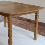 Table extensible Henning Kjærnulf en chêne massif avec pieds sculptés et deux rallonges intégrées, design danois années 60.
