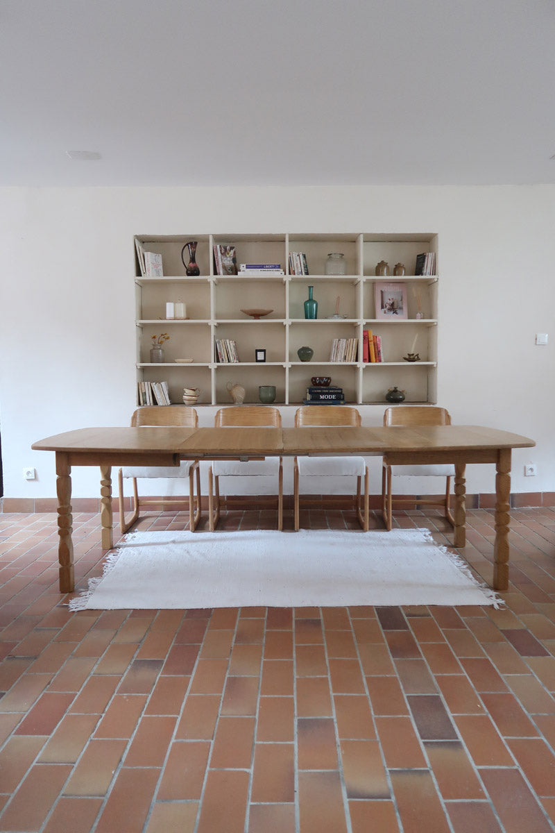 Table extensible Henning Kjærnulf en chêne massif avec pieds sculptés et deux rallonges intégrées, design danois années 60.