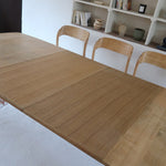 Table extensible Henning Kjærnulf en chêne massif avec pieds sculptés et deux rallonges intégrées, design danois années 60.