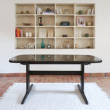 Table à manger Skovby en teck foncé avec plateau noir, piétement traîneau et deux rallonges, design danois des années 70.